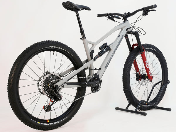 Rear view of Nukeproof Mega 275 RS X01 Eagle CARBON bike, highlighting its sturdy design and components including Pirelli tires.