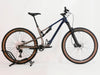 Front side angle of the Rocky Mountain Instinct Alloy 10 2023 mountain bike, showcasing its robust tyres and brake system, available at eMado Bikes.