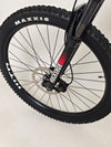 The Whyte 801 V4 2023 mountain bike resting against a wooden fence, illustrating its rugged style.
