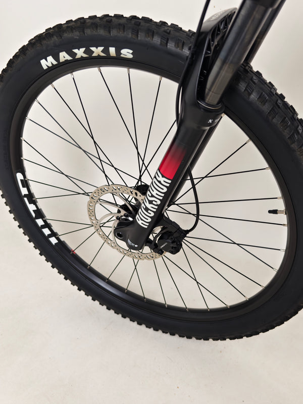 The Whyte 801 V4 2023 mountain bike resting against a wooden fence, illustrating its rugged style.