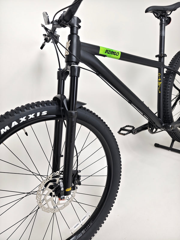 VooDoo Bizango mountain bike shown in natural outdoor setting, demonstrating its versatility.
