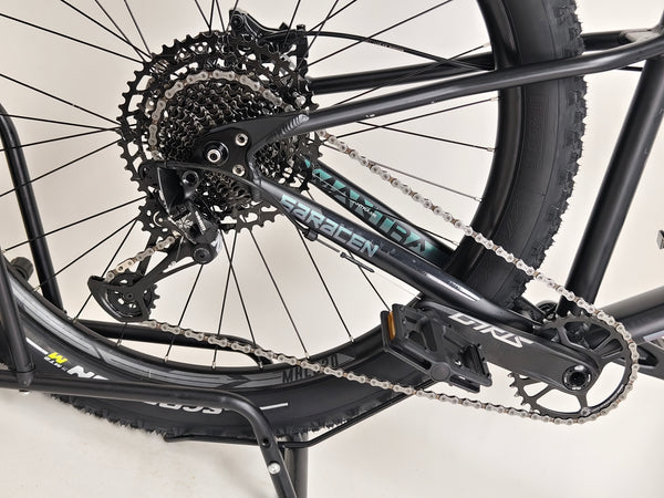 Macro view of the disc brake and wheel hub on the Saracen Mantra Elite LSL 2021 bike, showcasing its stopping power. Available at eMado.