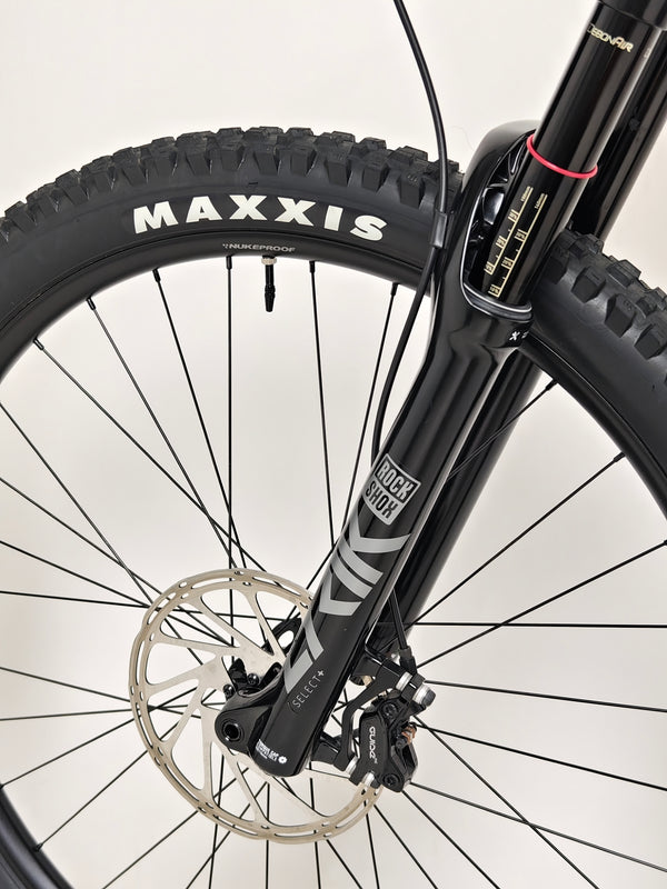 Detail of the Maxxis tread pattern showcasing mountain-ready features on the Nukeproof Reactor 290 PRO 2023 at eMado Bikes.