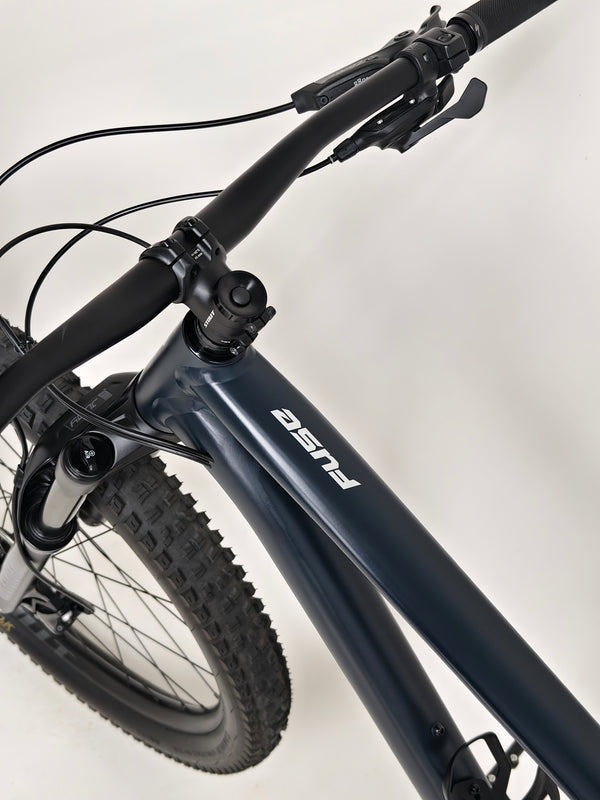 Handlebar close-up showcasing shifters and grips on Specialized Fuse Sport 27.5 2024 in Excellent Condition at eMado Bikes.