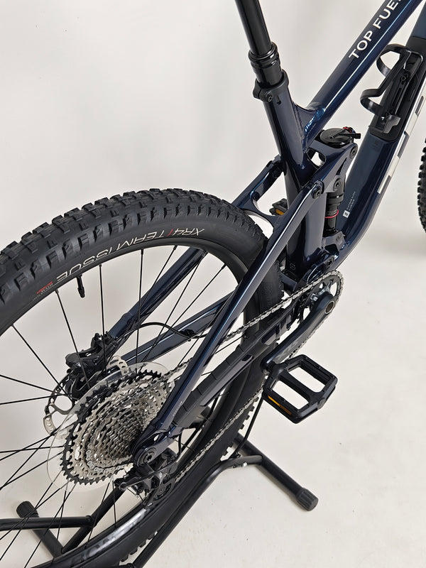 Trek Top Fuel 8 2024 Large Frame Full Suspension Bike at eMado - Image portraying the bike in action during a ride.