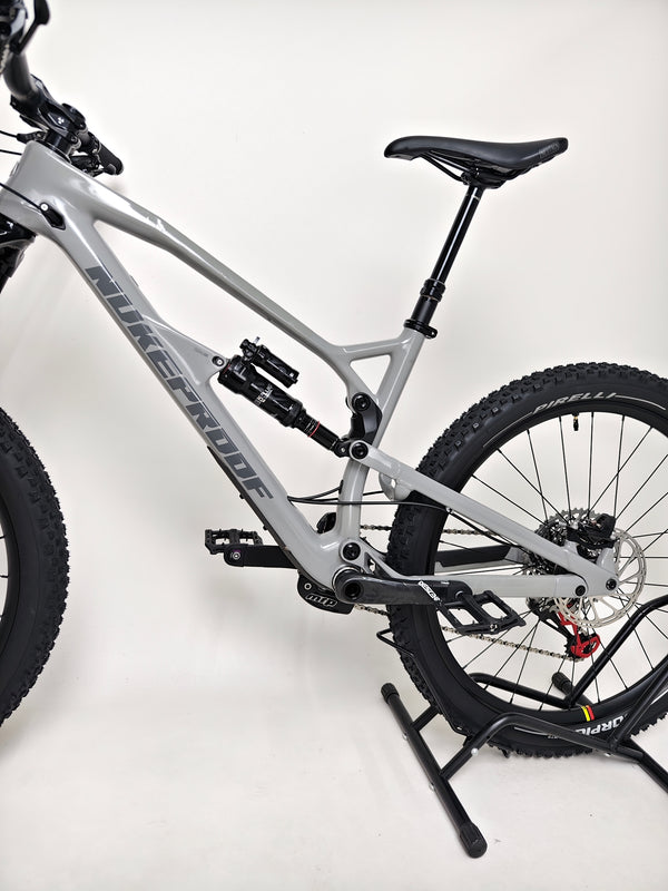 Detail of the Nukeproof Mega 275 RS X01 Eagle bike's seat and dropper post, showcasing the performance-focused design.