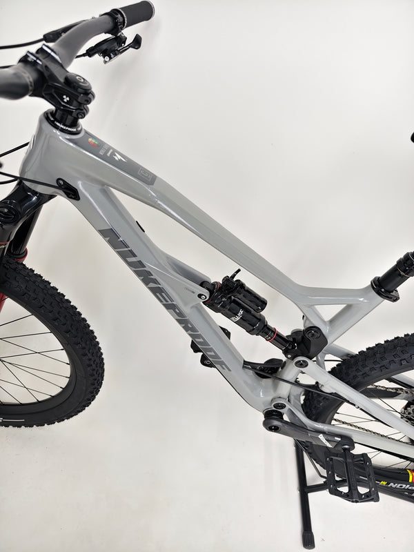 Nukeproof Mega 275 RS X01 Eagle bike highlighting the handlebar and stem setup for precise handling.