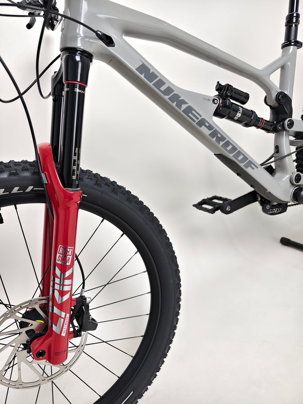 Nukeproof Mega 275 RS X01 Eagle bike front suspension and wheels, highlighting Pirelli Scorpion tires for all-terrain capability.