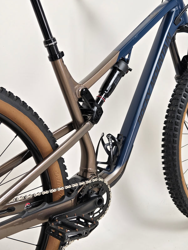 Rear angle view of Rocky Mountain Instinct Alloy 10 2023, emphasizing the robust tyre design and frame styling, available at eMado Bikes.