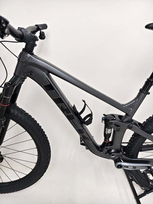 Trek Top Fuel 8 GX AXS 2024 LARGE Frame in Excellent Condition at eMado Bikes neatly positioned against a picturesque landscape.