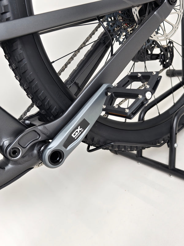 The Trek Top Fuel 8 GX AXS 2024 LARGE Frame in Excellent Condition at eMado Bikes amidst a vibrant trail setting.