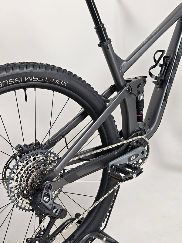 Trek Top Fuel 8 GX AXS 2024 LARGE Frame in Excellent Condition at eMado Bikes positioned against nature, ideal for browsing users.