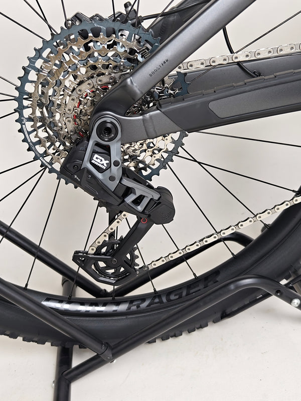 Trek Top Fuel 8 GX AXS 2024 LARGE Frame in Excellent Condition at eMado Bikes positioned outdoors, ideal for prospective buyers inspecting the bike.