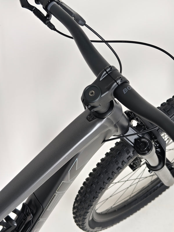 Highlighting the Trek Top Fuel 8 GX AXS 2024 LARGE Frame in Excellent Condition at eMado Bikes along a mountain path.