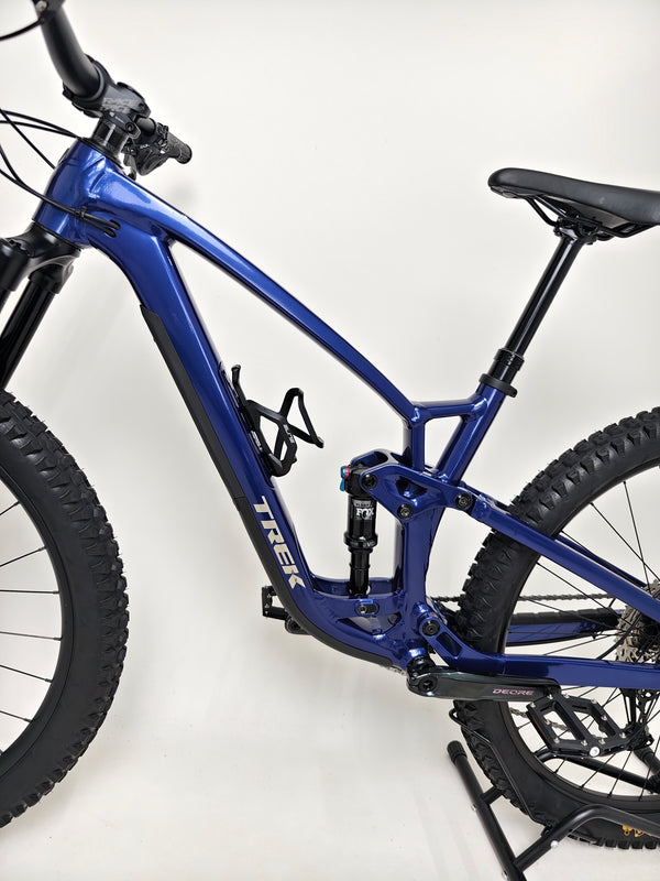 Trek Fuel EX 7 2024 Gen 6 (upgraded), M-L in Very Good Condition - showcasing the bike parked in nature.