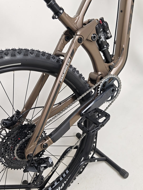 View of the bike's suspension system on the Transition Smuggler NX 2024 in medium, essential for performance.