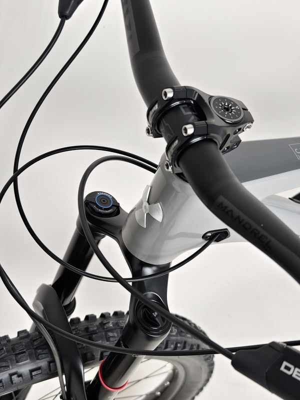Nukeproof Mega 290 CARBON - Detailed view of front suspension setup on rugged terrain.