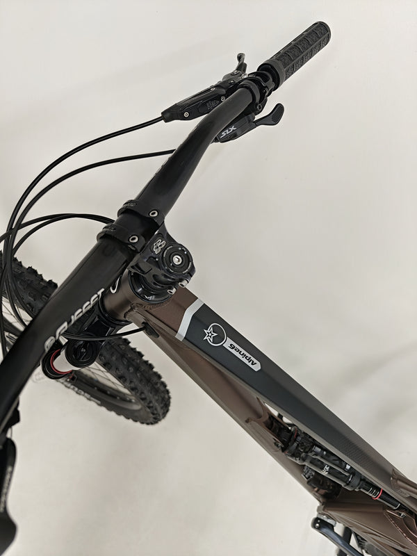 Close-up of the front fork and shock details on the Orange ALPINE 6 mountain bike.