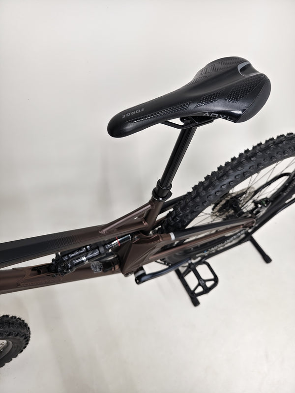 The Orange ALPINE 6 Full Suspension Mountain Bike in action on a rugged trail.