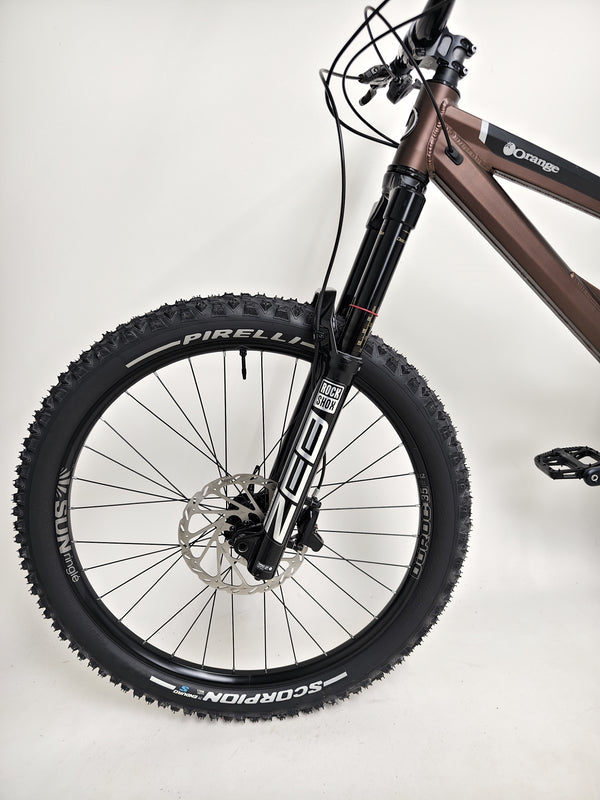 Side profile of the Orange ALPINE 6 mountain bike showcasing powerful performance features.