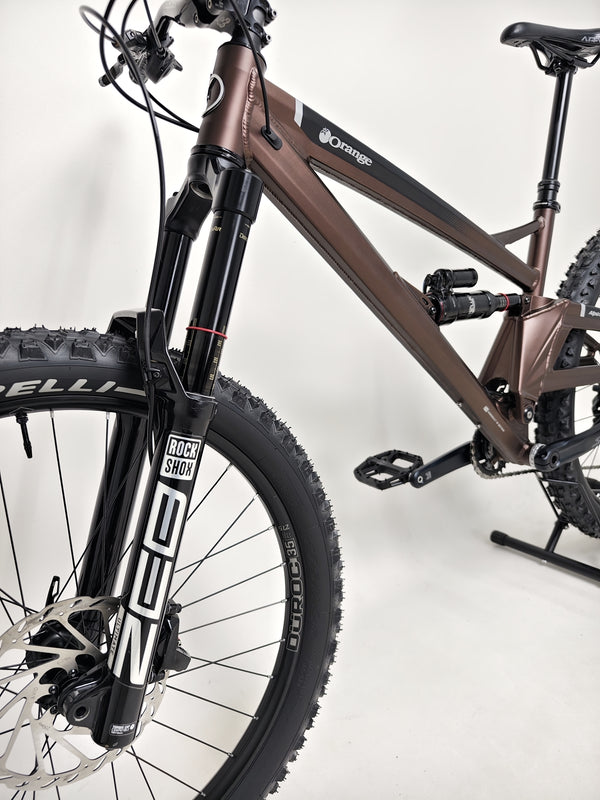 Rider on the Orange ALPINE 6 Full Suspension Mountain Bike on a scenic mountain trail.