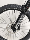 Compact shot of the Orange ALPINE 6 mountain bike in a garage, under professional lighting.