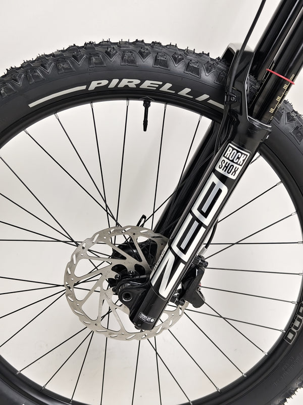 Compact shot of the Orange ALPINE 6 mountain bike in a garage, under professional lighting.