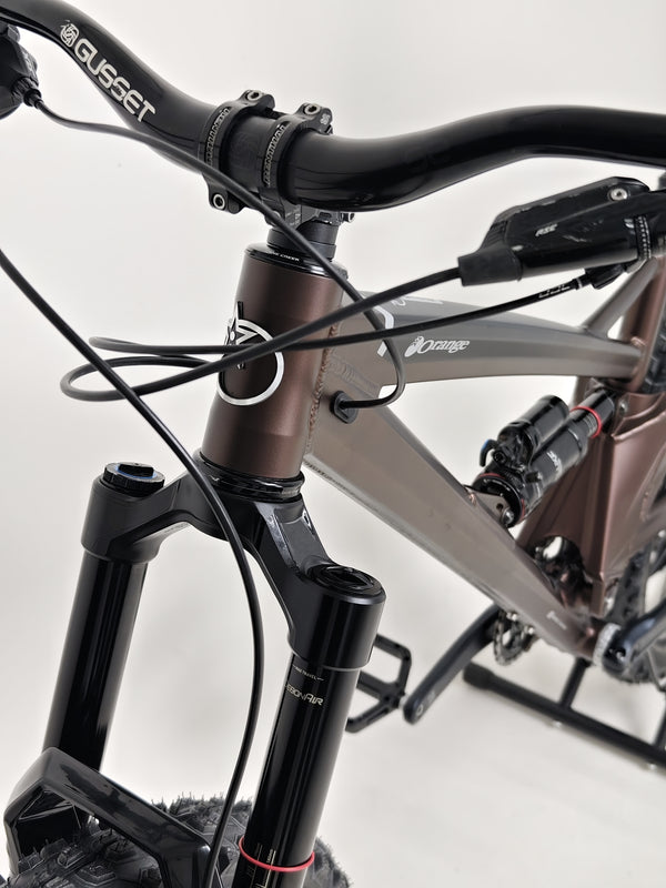 Professional cyclist handling the Orange ALPINE 6 mountain bike during a climb.