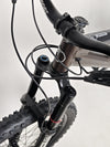 Action shot of the Orange ALPINE 6 mountain bike navigating through challenging terrain.
