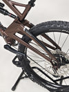 Orange ALPINE 6 mountain bike positioned against a classic stone wall, blending old and new.
