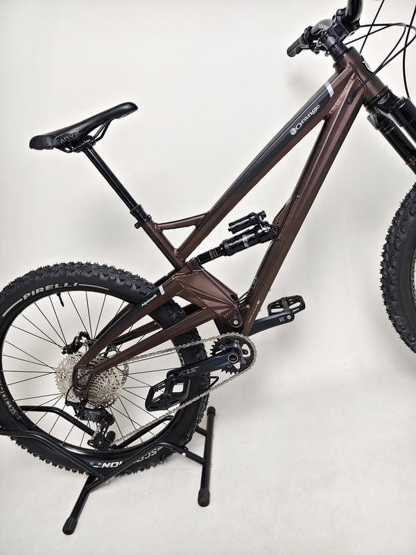 The Orange ALPINE 6 Full Suspension Mountain Bike with a beautiful landscape in the background.