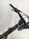 A close-up perspective of the Orange ALPINE 6 mountain bike's crankset and pedals.