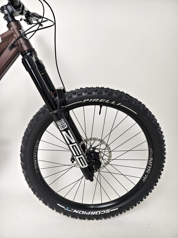 Dynamic shot of a biker riding the Orange ALPINE 6 mountain bike down a steep hill.