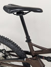 Detailed view of the Orange ALPINE 6's rear shock absorber functioning under pressure.
