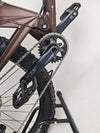 The Orange ALPINE 6 mountain bike in action, climbing a steep trail.