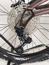 The Orange ALPINE 6 mountain bike positioned confidently at the edge of a cliff.