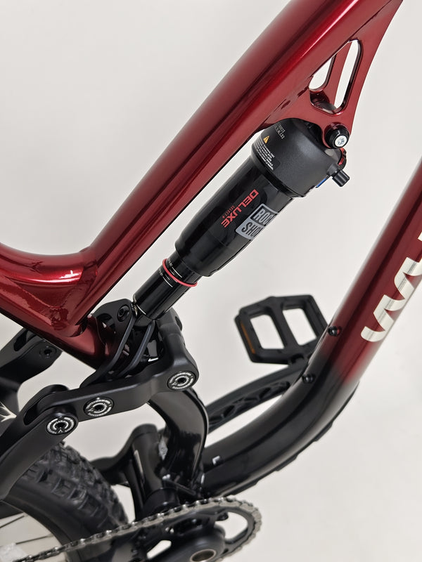 Wide shot of the Whyte T-160 S 2025 mountain bike over rocky terrain, emphasizing durability.