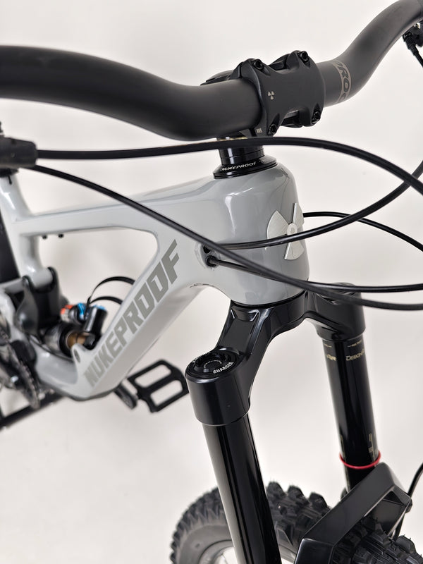 Nukeproof Giga 290 Comp Carbon 2022 bike positioned in an urban setting.