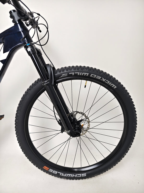 Another view of the Trek Top Fuel 9.7 2022 CARBON bike emphasizing its wheels and suspension.