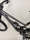 The vibrant colours of the Specialized Status 160, focusing on its satin smoke frame against a natural backdrop.
