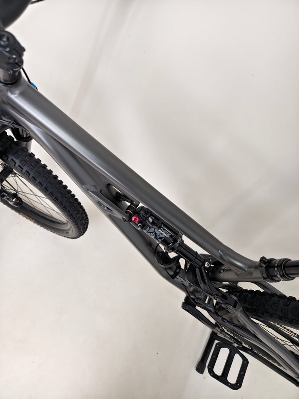 Dynamic action shot of the Specialized Status 160 in motion on a mountain biking trail.