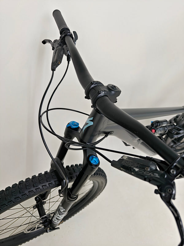 Scenic shot of the Specialized Status 160 on a mountain path highlighting its off-road capabilities.