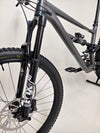 Specialized Status 160 mountain bike on a trail, demonstrating its full suspension in action.