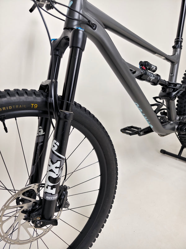 Specialized Status 160 mountain bike on a trail, demonstrating its full suspension in action.