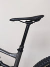 A close-up of the tires on the Specialized Status 160, showcasing their tread pattern designed for trail efficiency.