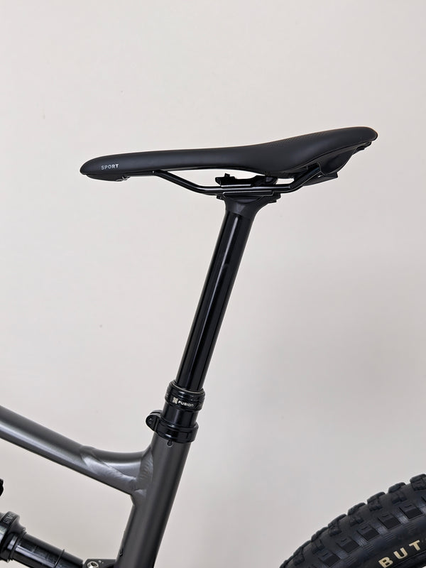 A close-up of the tires on the Specialized Status 160, showcasing their tread pattern designed for trail efficiency.