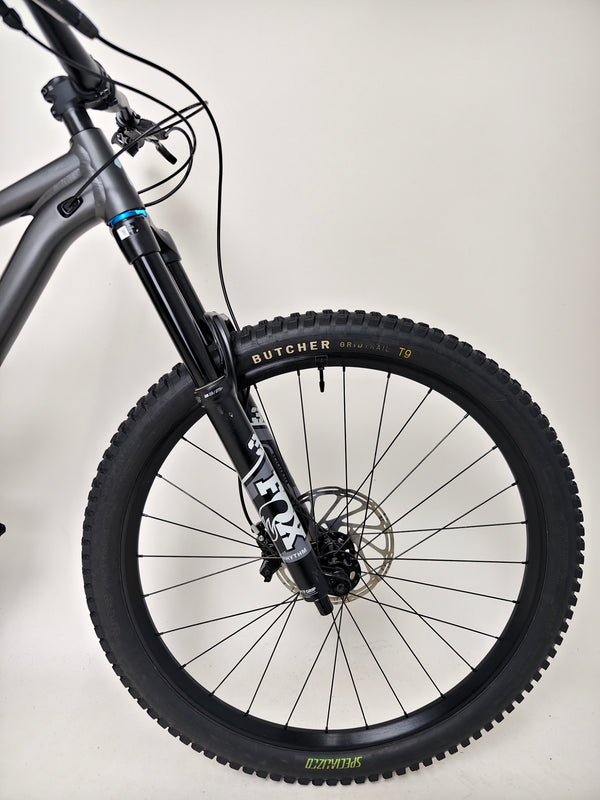 Side profile of the Specialized Status 160 displaying its mixed wheel trail geometry on a path.