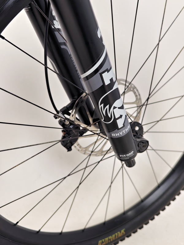 Action shot of the Specialized Status 160 navigating rough terrain, demonstrating durability and control.