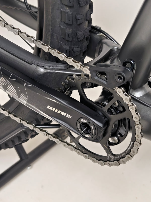 The sleek profile of the Specialized Status 160 mountain bike against a forest background.
