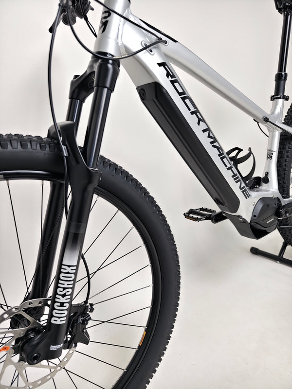 Close-up of the Rock Machine Blizz e60-29 Electric Mountain Bike featuring Rockshox suspension and sleek design.